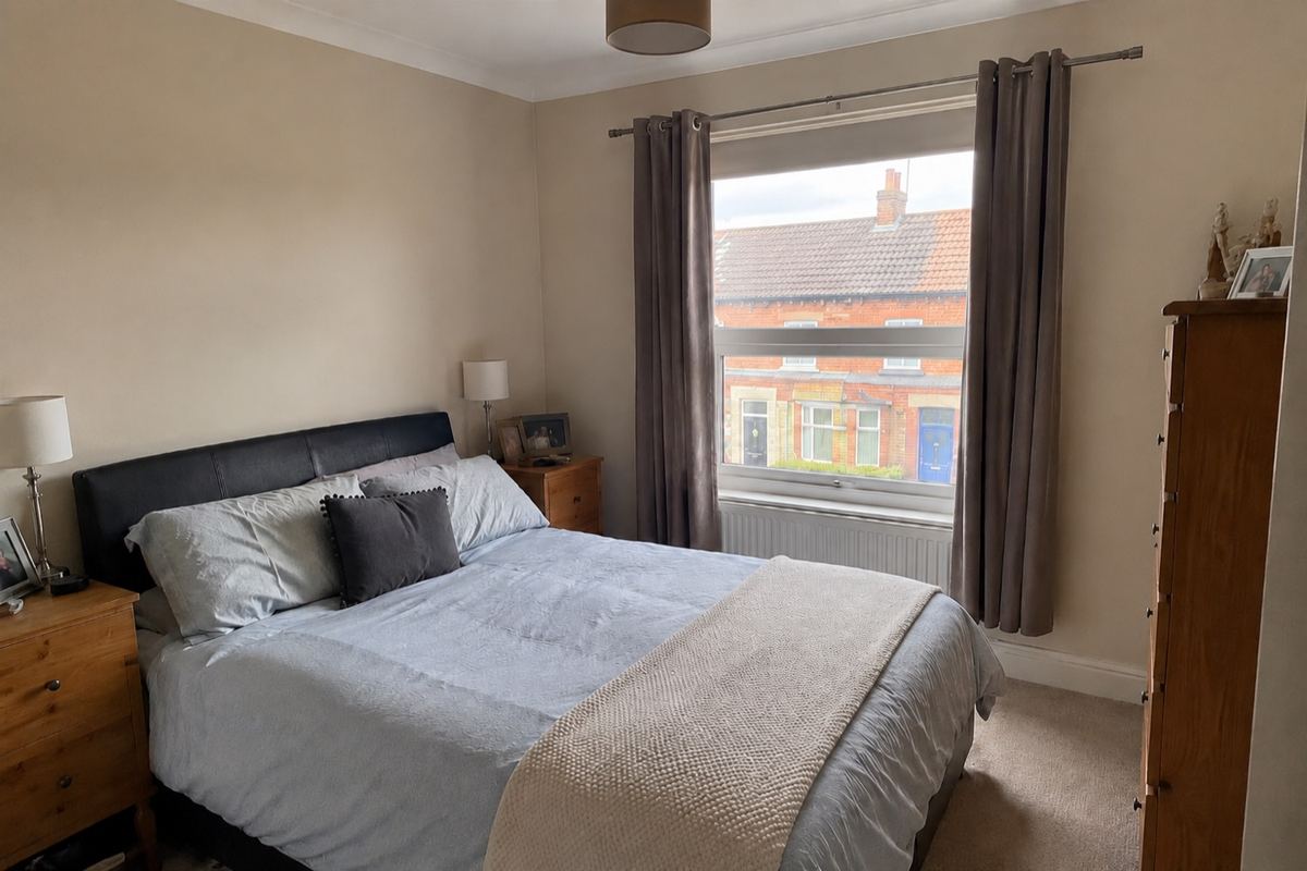 Original British bedroom with a bed, bedside tables and wardrobe before its makeover.