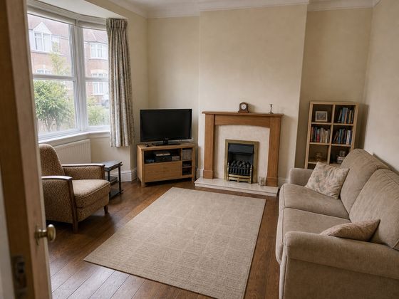 Plain magnolia Victorian terrace living room with bay window, fireplace, beige sofa and dated curtains before its remodel.